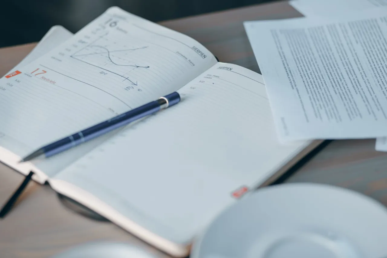 Cuaderno con una gráfica dibujada a mano, apuntes y un bolígrafo sobre la mesa