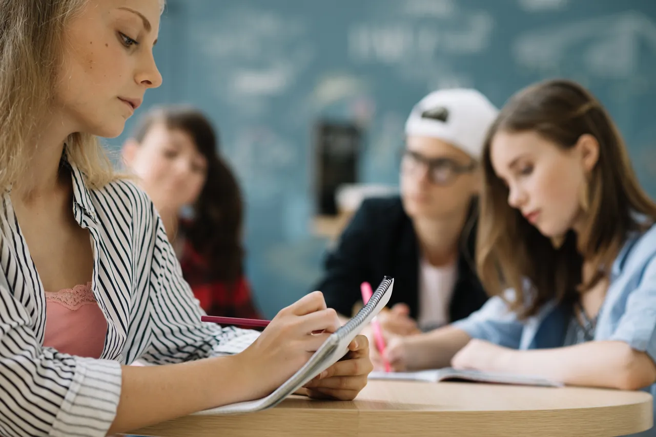 Alumno de ESO trabajando matemáticas con apuntes sobre la mesa