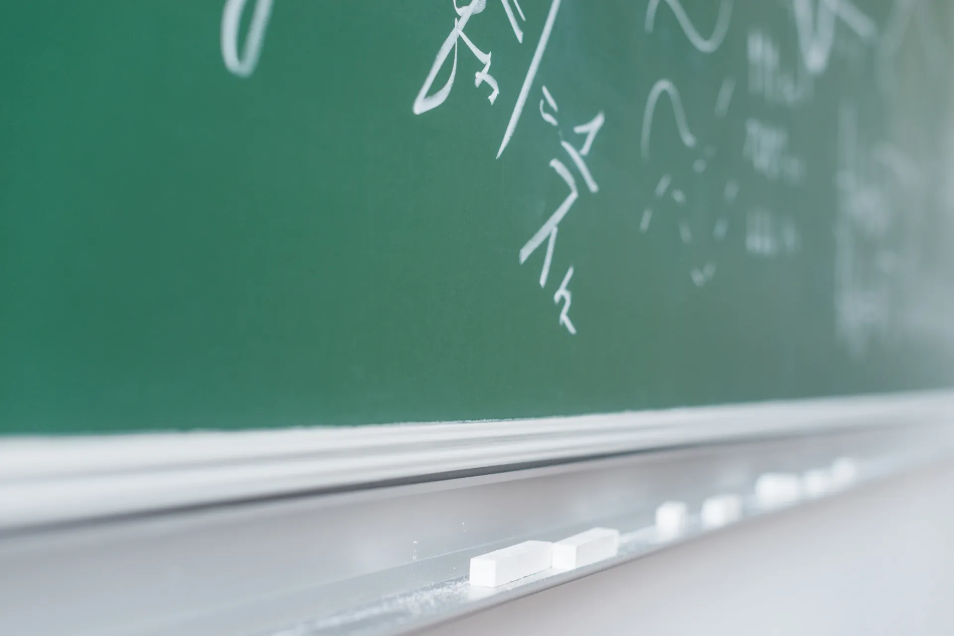 Ecuaciones de matemáticas de bachillerato escritas con tiza en una pizarra verde